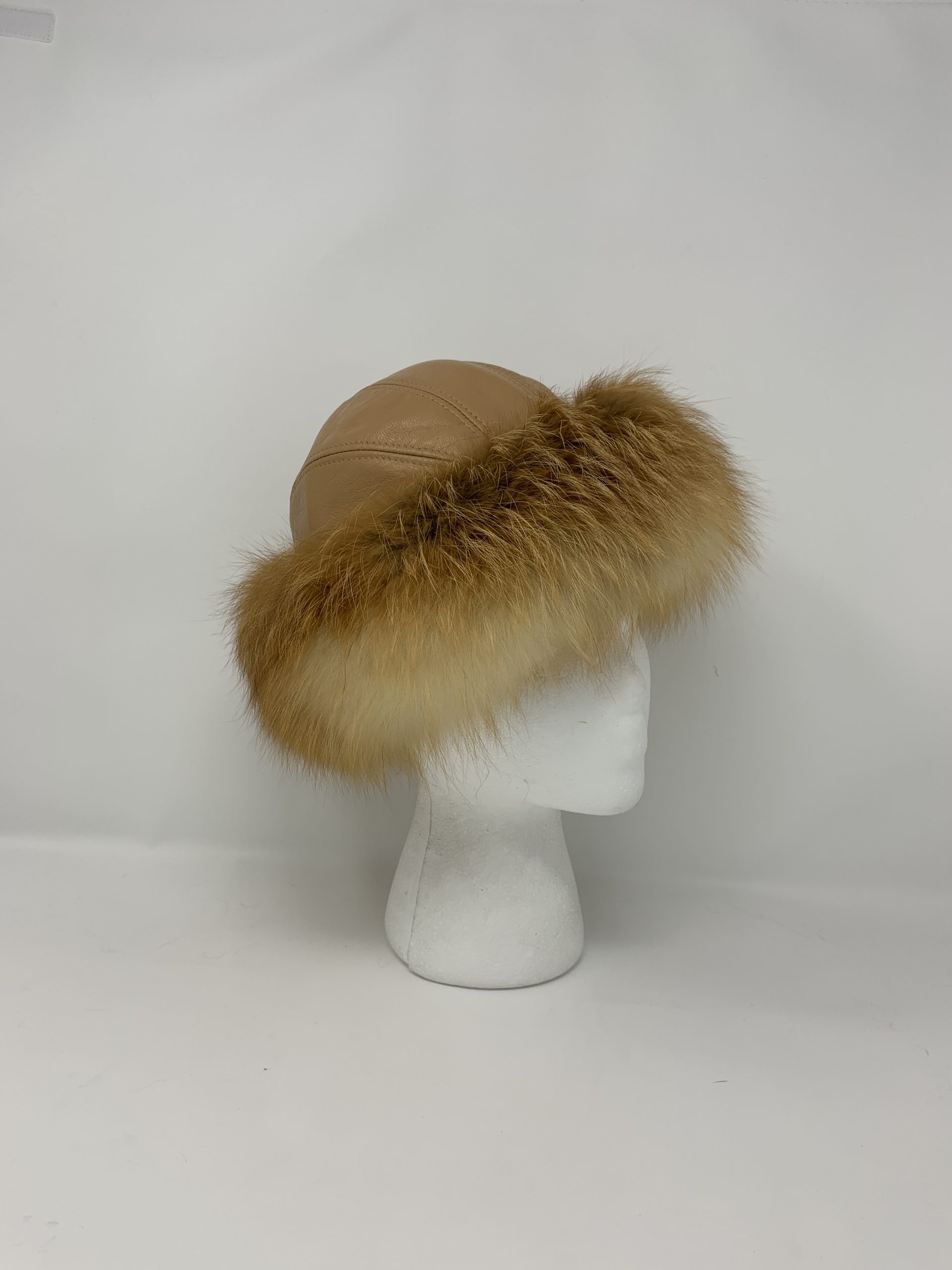 IMG_1848-scaled-1.jpg Our tan leather hat with natural red fox trim is a charming and warm accessory for any winter wardrobe. Its smooth tan leather provides a classic and durable base. The vibrant red fox fur trim adds a pop of color and extra coziness.