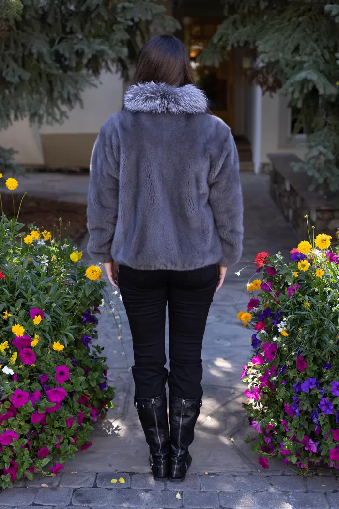 This dyed blue iris mink zip-up jacket with indigo fox trim blends rich color with soft luxury. The blue mink creates a sleek base, while the indigo fox trim adds texture and warmth. This jacket enhances your style with elegance and keeps you cozy on colder days.