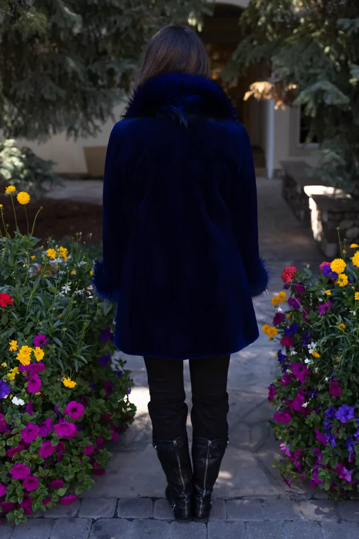 This dyed blue sheared mink stroller features a dyed blue silver fox collar and cuffs. Together, they offer bold style and cozy warmth. The sleek...