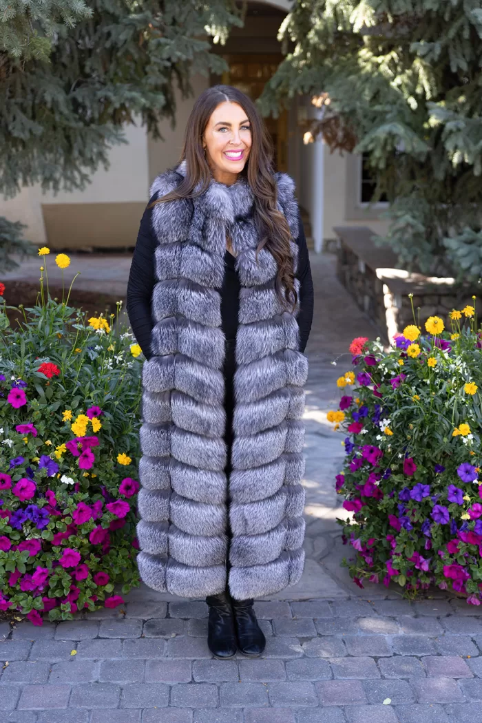 Natural Silver Fox Duster Vest brings luxurious style and warmth to any outfit. The soft silver fox fur showcases its natural blend of gray, black, and white tones, creating a stunning visual effect. The long duster design adds elegance, making it a perfect statement piece for any occasion.