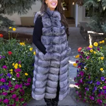 Natural Silver Fox Duster Vest brings luxurious style and warmth to any outfit. The soft silver fox fur showcases its natural blend of gray, black, and white tones, creating a stunning visual effect. The long duster design adds elegance, making it a perfect statement piece for any occasion.