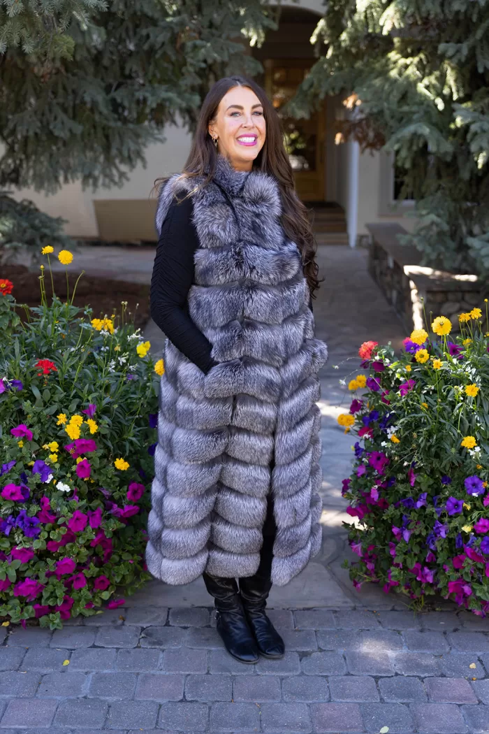 Natural Silver Fox Duster Vest brings luxurious style and warmth to any outfit. The soft silver fox fur showcases its natural blend of gray, black, and white tones, creating a stunning visual effect. The long duster design adds elegance, making it a perfect statement piece for any occasion.