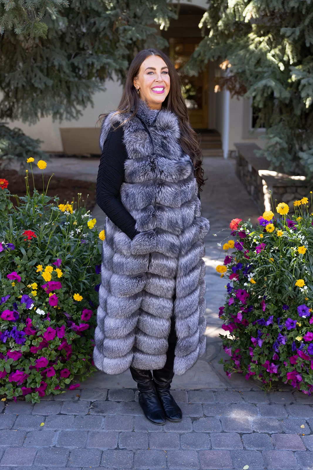 Fantasia Furs Natural Silver Fox Duster Vest brings luxurious style and warmth to any outfit. The soft silver fox fur showcases its natural blend of gray, black, and white tones, creating a stunning visual effect. The long duster design adds elegance, making it a perfect statement piece for any occasion.