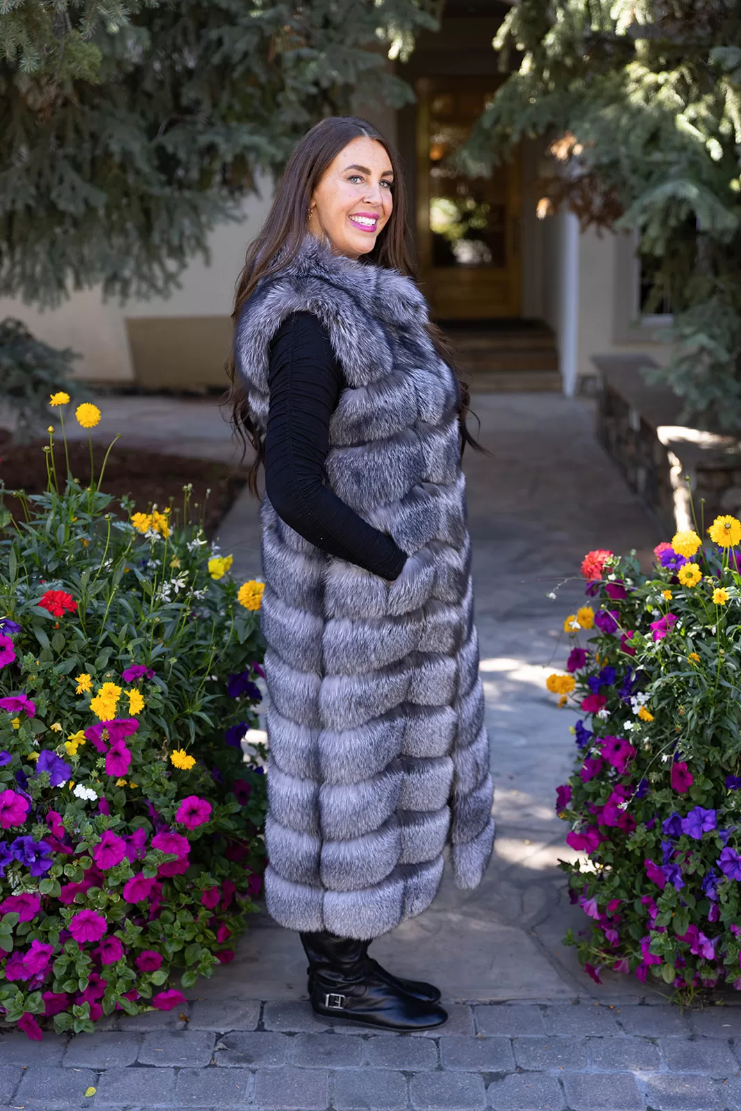 Fantasia Furs Natural Silver Fox Duster Vest brings luxurious style and warmth to any outfit. The soft silver fox fur showcases its natural blend of gray, black, and white tones, creating a stunning visual effect. The long duster design adds elegance, making it a perfect statement piece for any occasion.