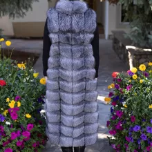 Natural Silver Fox Duster Vest brings luxurious style and warmth to any outfit. The soft silver fox fur showcases its natural blend of gray, black, and white tones, creating a stunning visual effect. The long duster design adds elegance, making it a perfect statement piece for any occasion.