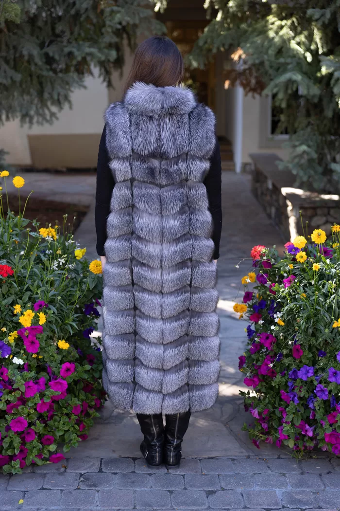 Natural Silver Fox Duster Vest brings luxurious style and warmth to any outfit. The soft silver fox fur showcases its natural blend of gray, black, and white tones, creating a stunning visual effect. The long duster design adds elegance, making it a perfect statement piece for any occasion.