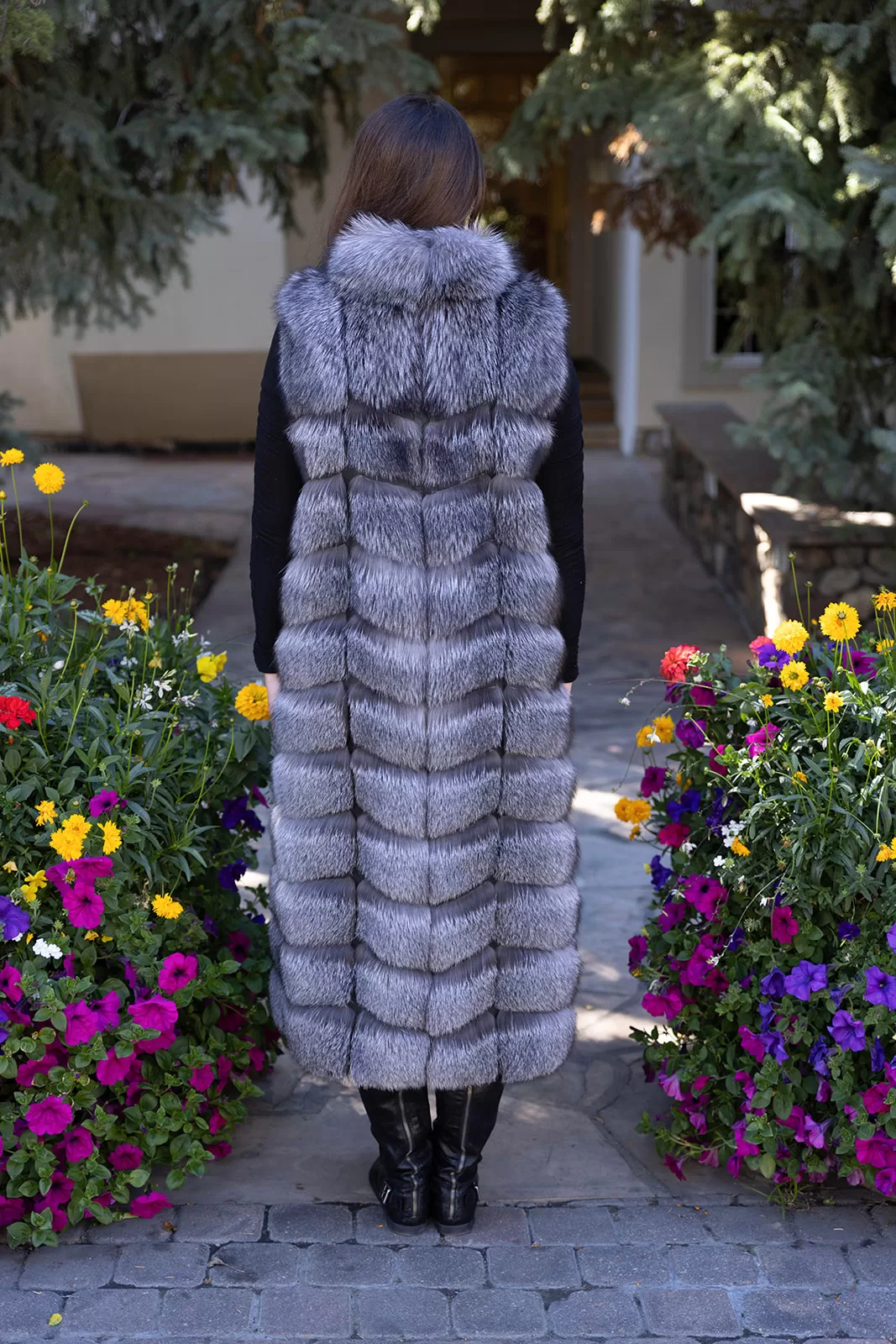 Fantasia Furs Natural Silver Fox Duster Vest brings luxurious style and warmth to any outfit. The soft silver fox fur showcases its natural blend of gray, black, and white tones, creating a stunning visual effect. The long duster design adds elegance, making it a perfect statement piece for any occasion.