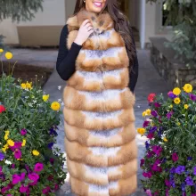 This natural red fox duster vest adds bold style and warmth to any outfit. The vibrant red fox fur creates a striking look, while the long duster design...