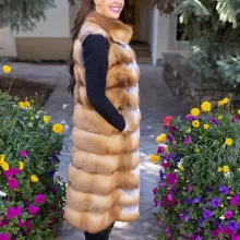 This natural red fox duster vest adds bold style and warmth to any outfit. The vibrant red fox fur creates a striking look, while the long duster design...