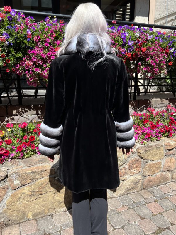 This dyed black sheared mink coat with natural chinchilla trim is beautiful and timeless. It is perfect for special occasions or adding a touch of...