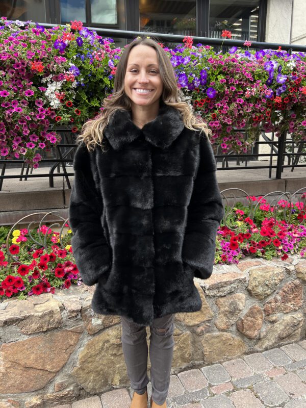 This dyed black ranch mink jacket offers elegance and warmth. Made from black mink fur, it has a rich color and soft texture.