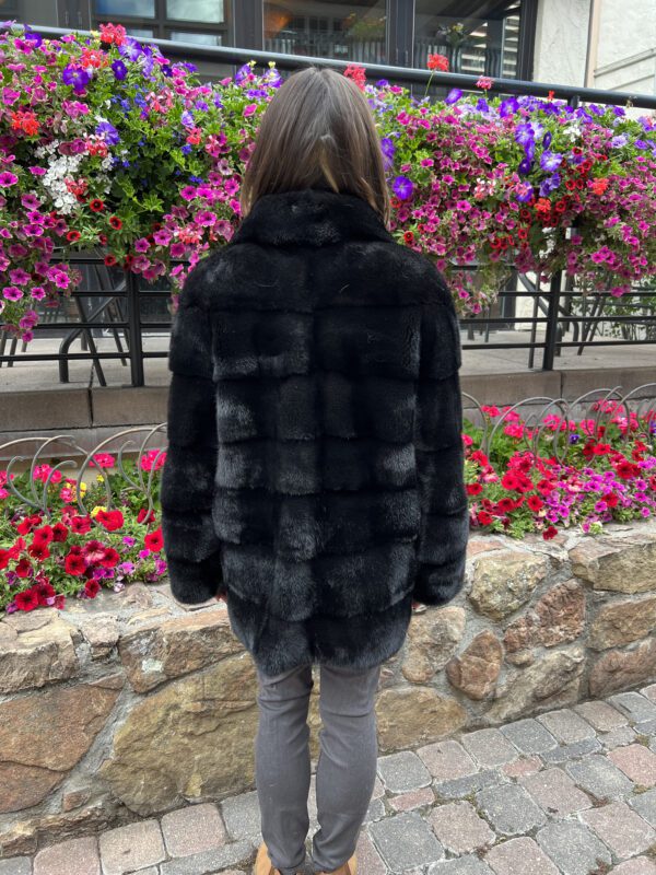 This dyed black ranch mink jacket offers elegance and warmth. Made from black mink fur, it has a rich color and soft texture.