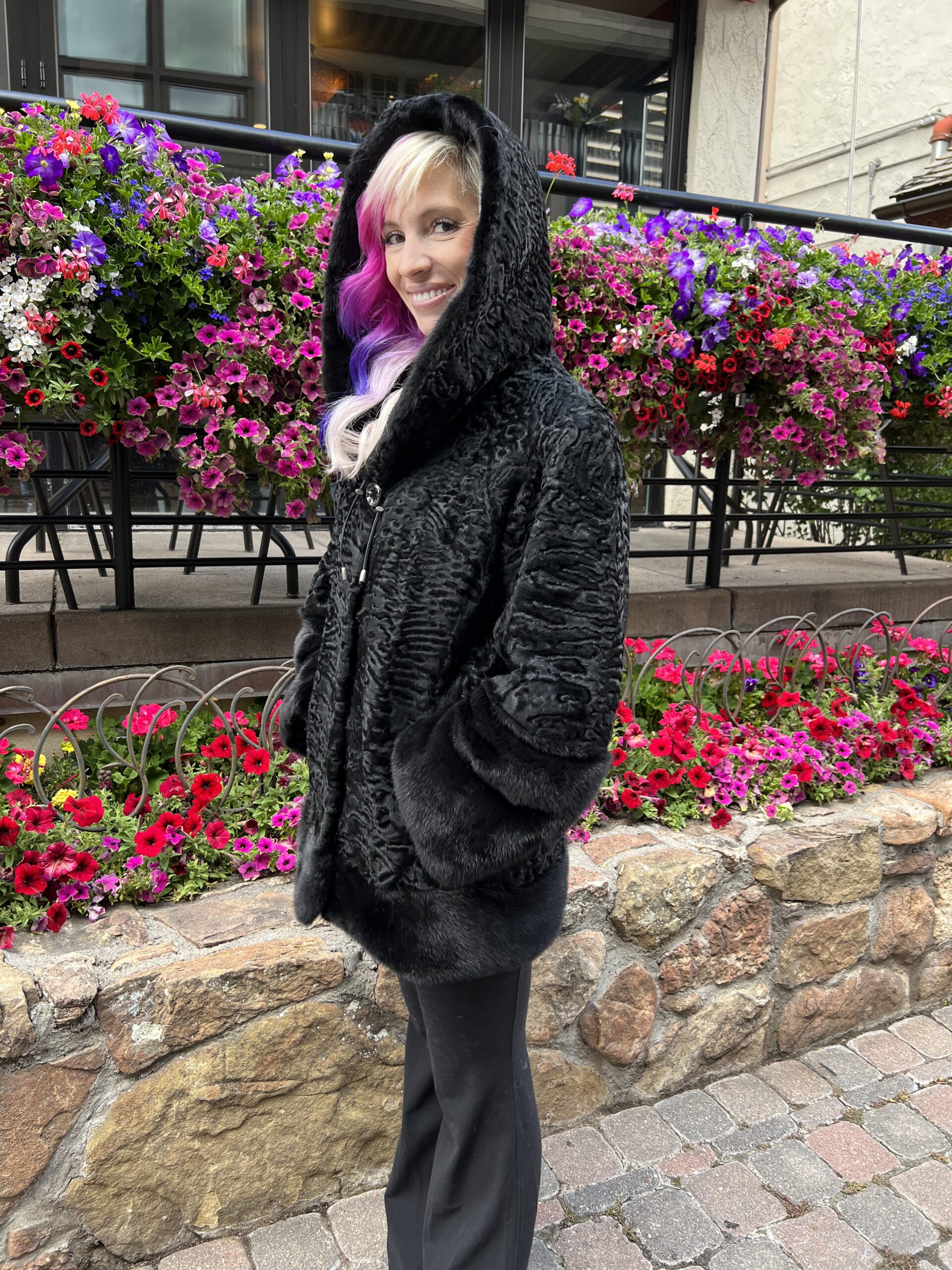 Our hooded dyed black Persian lamb jacket with dyed black mink trim is elegant and cozy. This jacket is a timeless and stylish addition to any wardrobe.